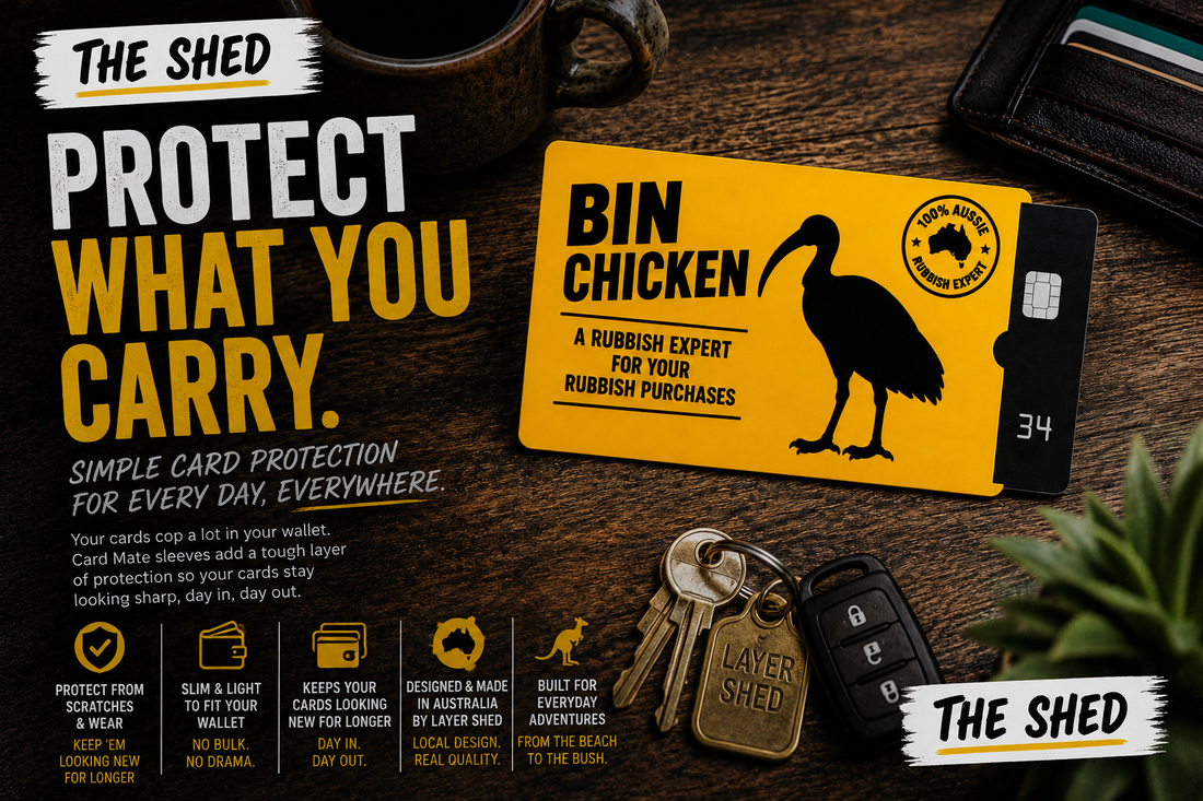 Layer Shed Card Mate Bin Chicken bank card sleeve protecting a debit card, with wallet and everyday essentials on a wooden table
