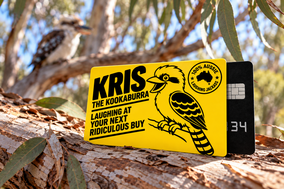 Kris the Kookaburra yellow card sleeve resting on a fallen eucalyptus branch with a blurred kookaburra in the background.